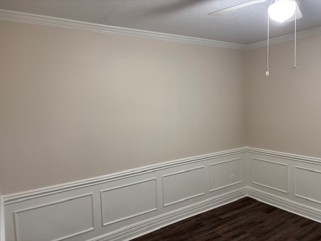 Room with dark wainscoting and rich wood floors