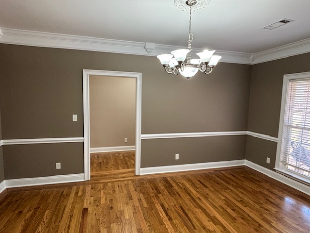 Formal dining room with taupe walls and hardwood flooring